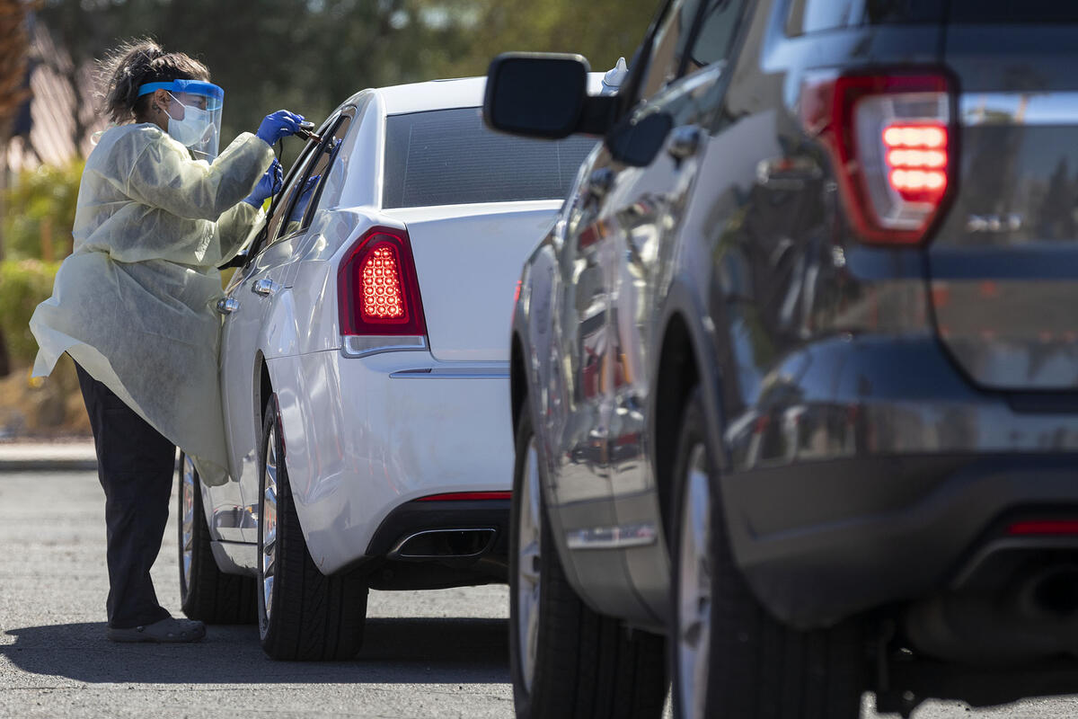 medical assistant reaching through a car window