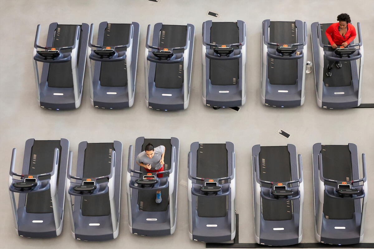 Two students, seen from above, use treadmills far apart