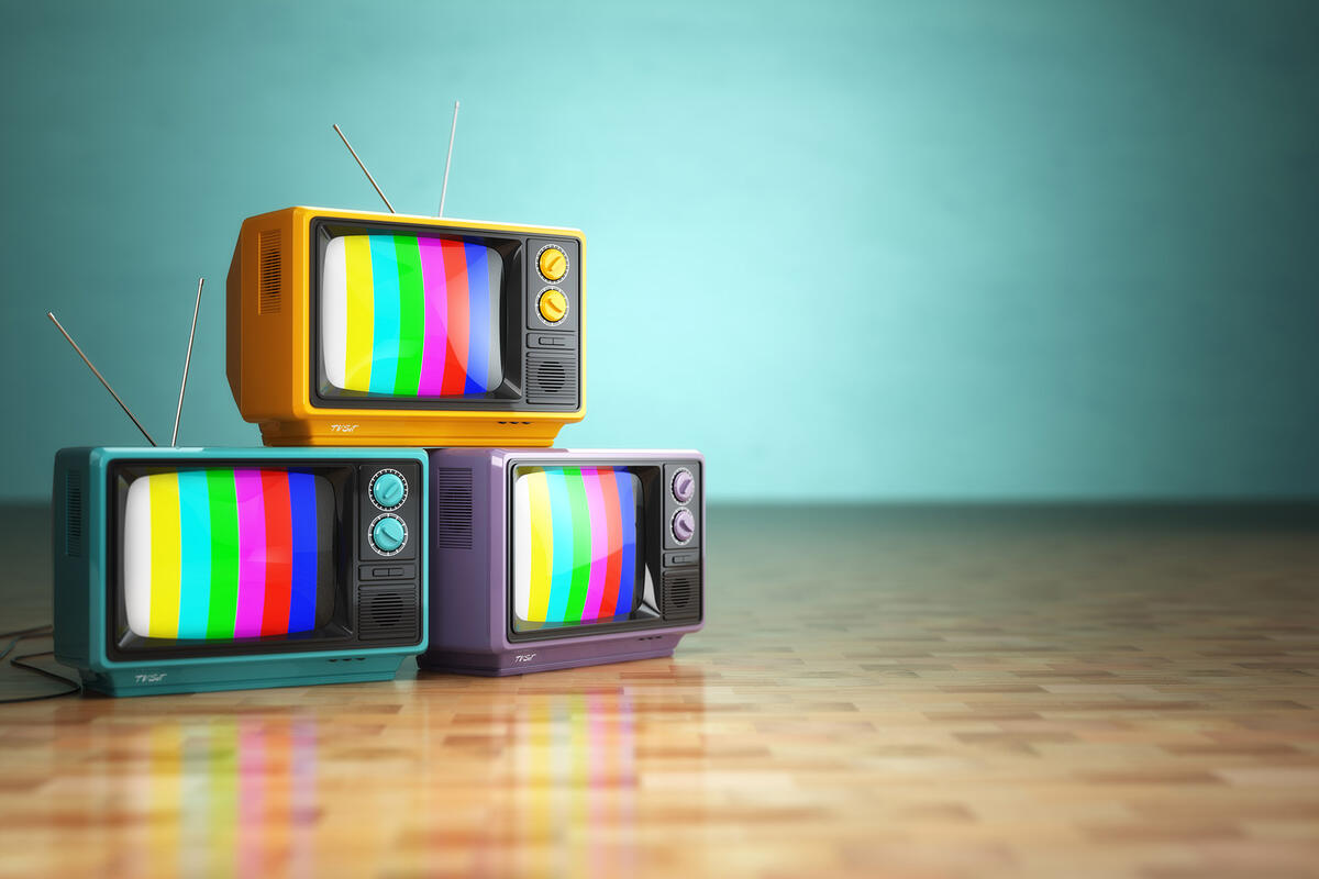 three stacked retro televisions displaying rainbow off-air signal