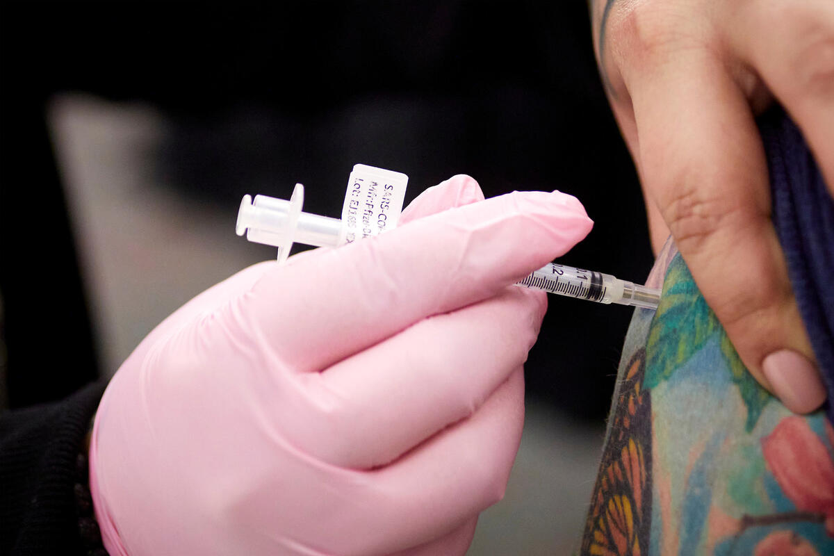 A person receives a vaccination shot in the shoulder