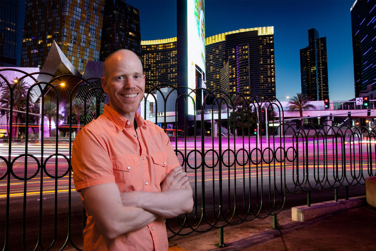 A man stands in front of the Las Vegas Strip at dusk
