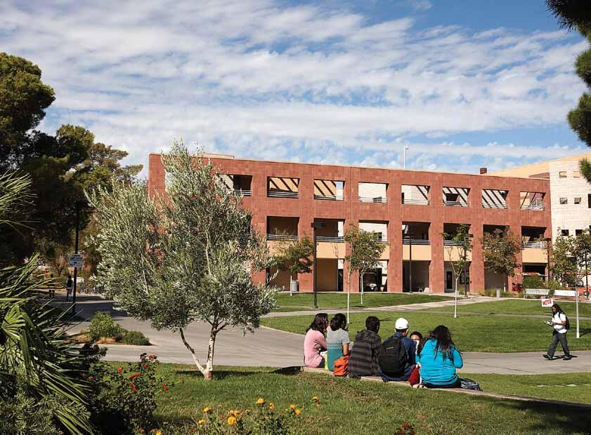 Students sitting at the Alumni Amphitheater with Wright Hall in the background
