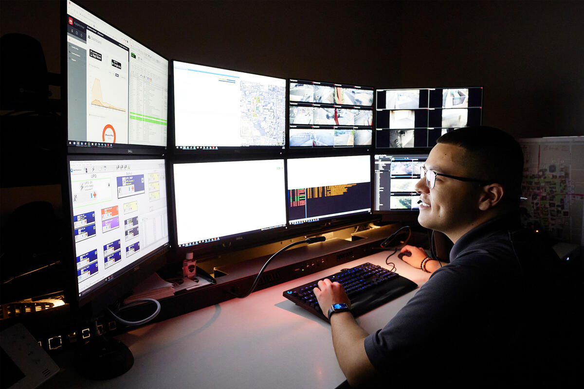 A man looks at a bank of eight computer monitors