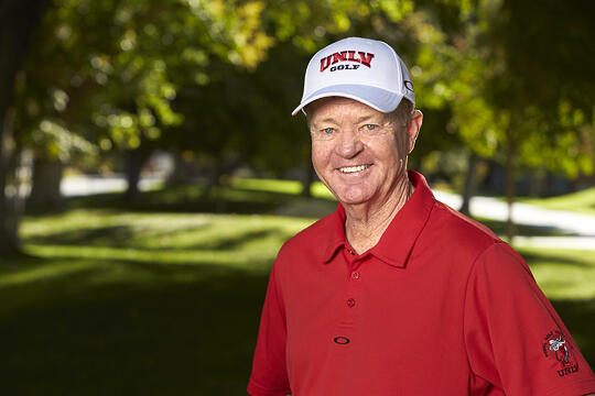 A man wearing a white hat and red polo shirt