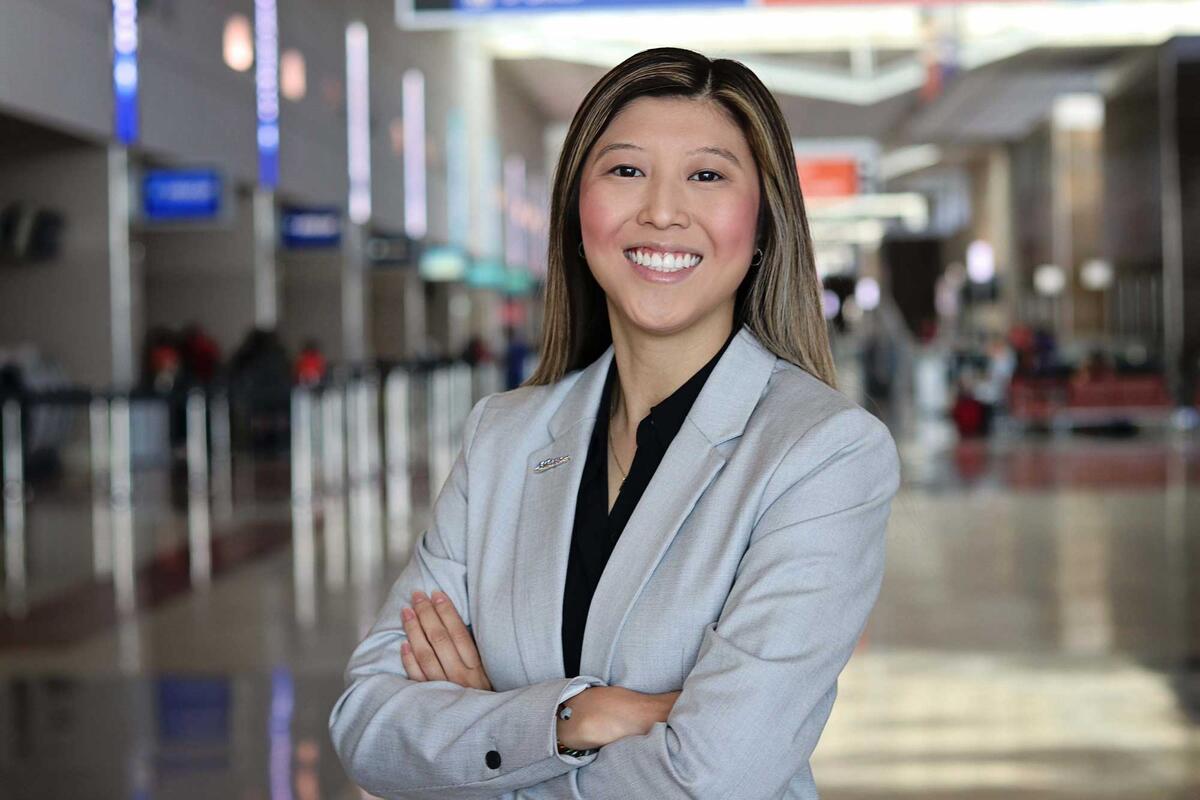 Kylies Fung stands in an airport.