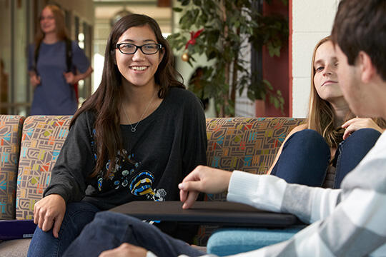 Three people talking at a lounge area