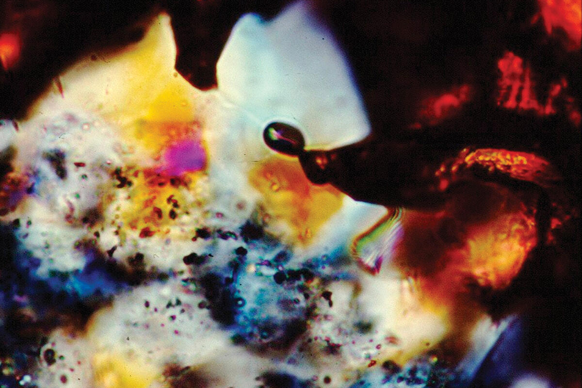 Microscopic view of multicolored slice of gold ore.