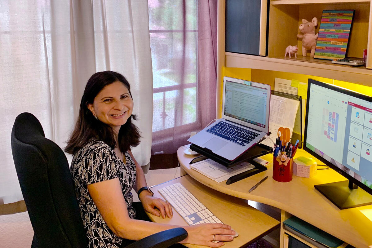 Debbie Pattni seated in front of a computer in her home office.