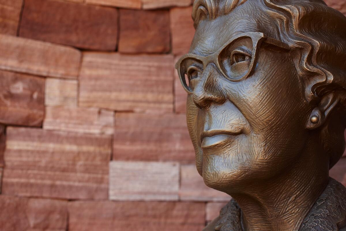 Bronze bust on red stone wall