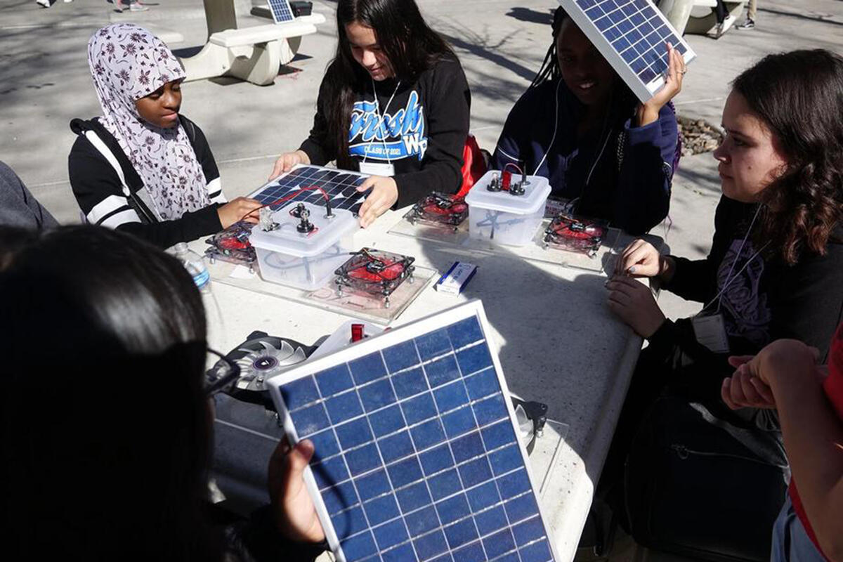 young women looking at solar components