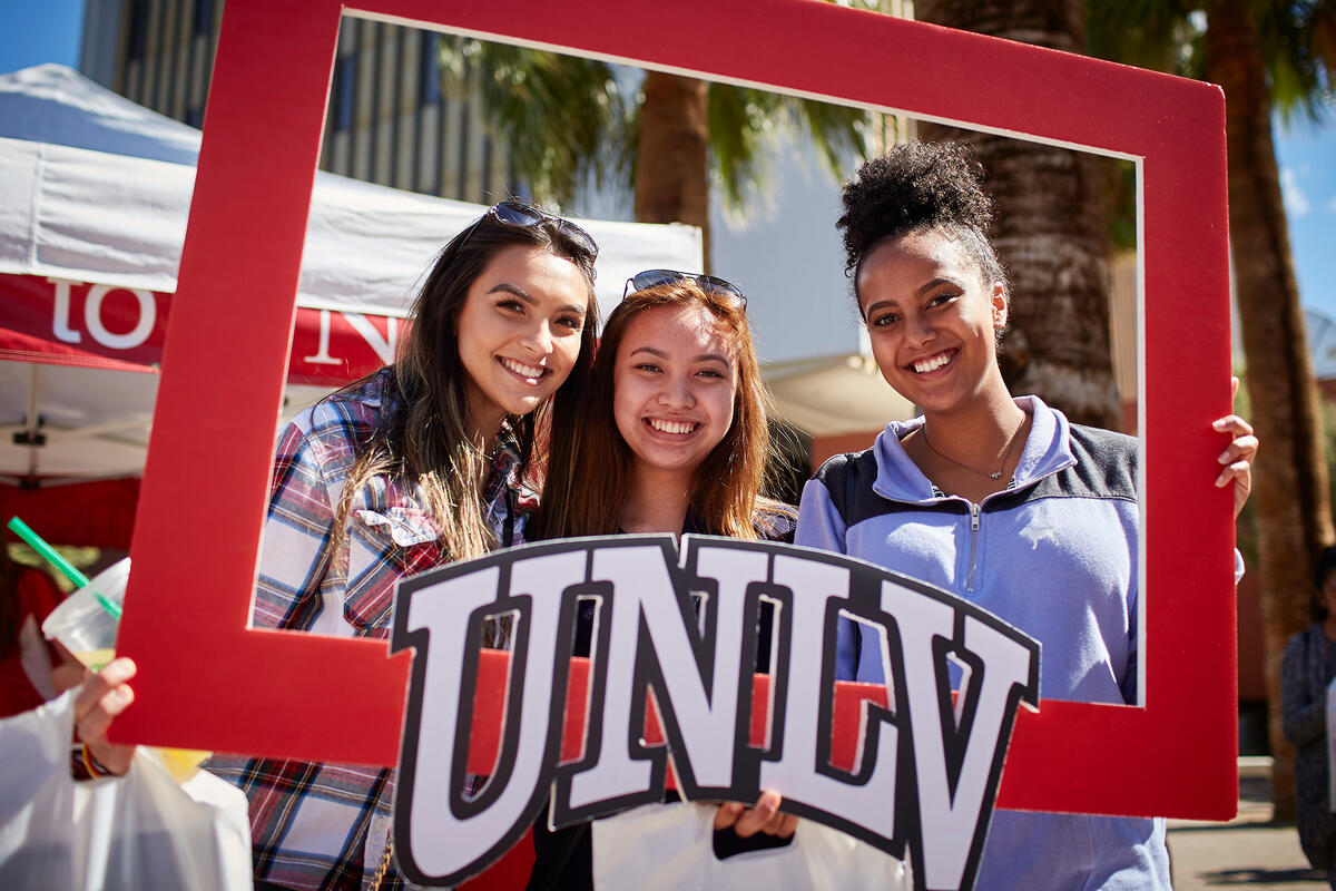 Students posing with UNLV poster frame