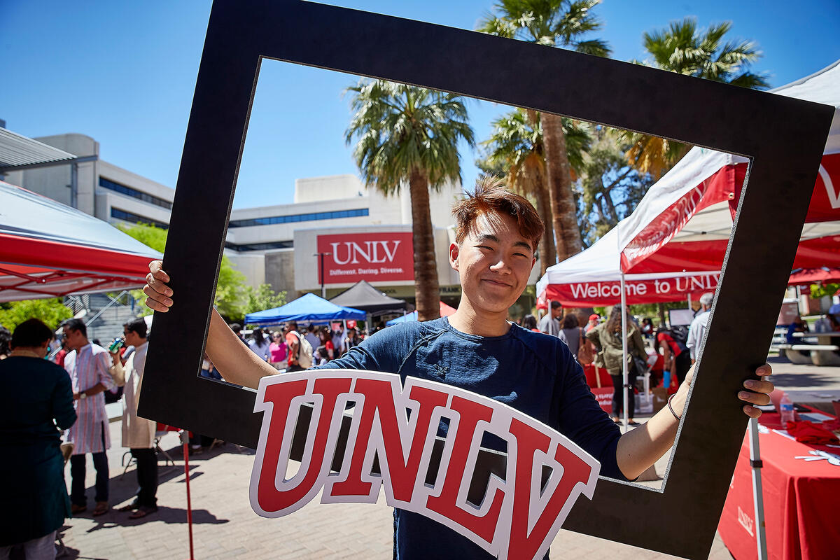 Student posing with UNLV poster frame
