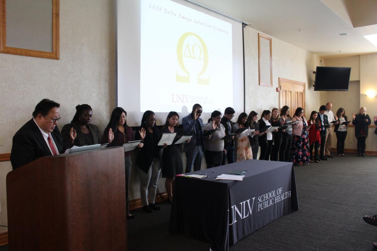 Group of people standing in a line with their hands up