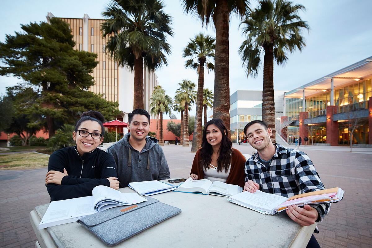 Students gather around a table outside the student union.
