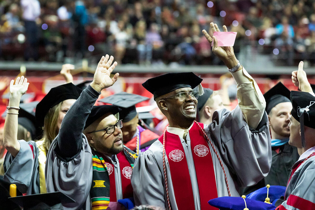 Graduates smiling and waving