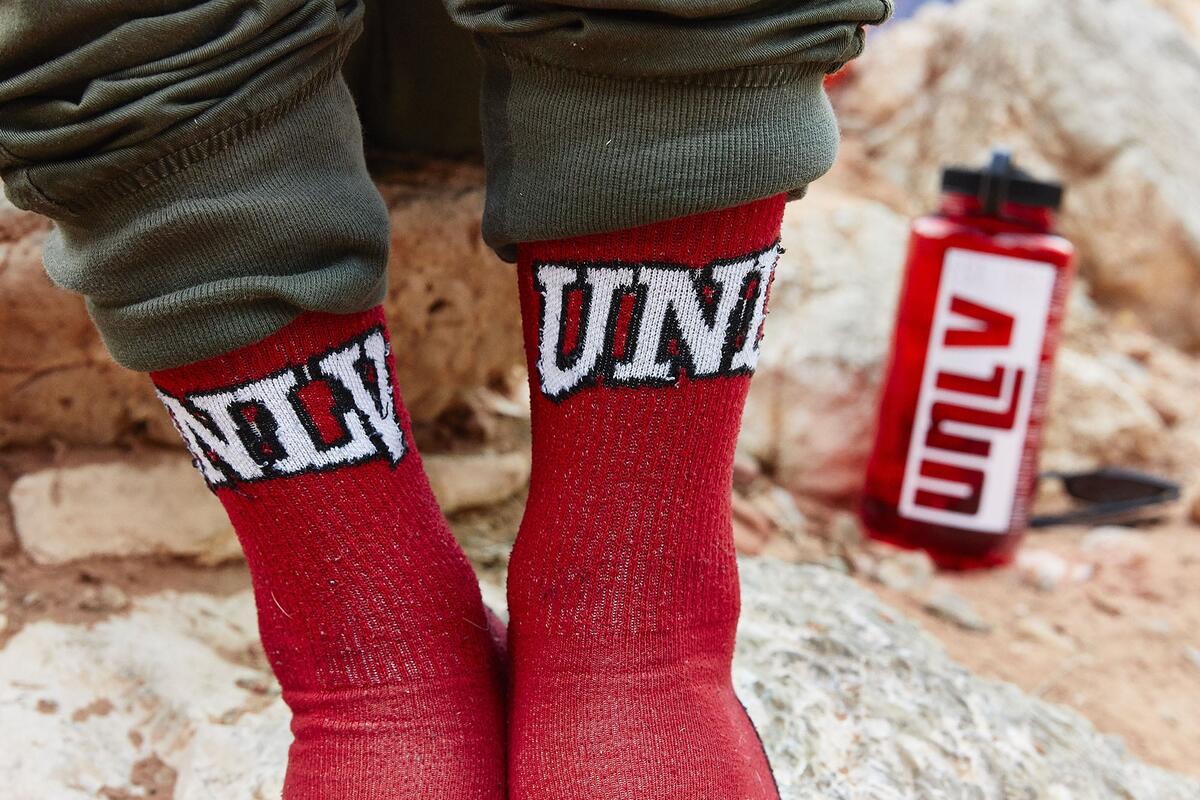A girl out in the country wearing her UNLV socks.