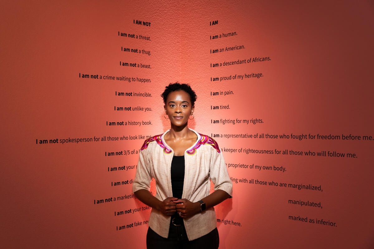 Black woman stands in front of art piece