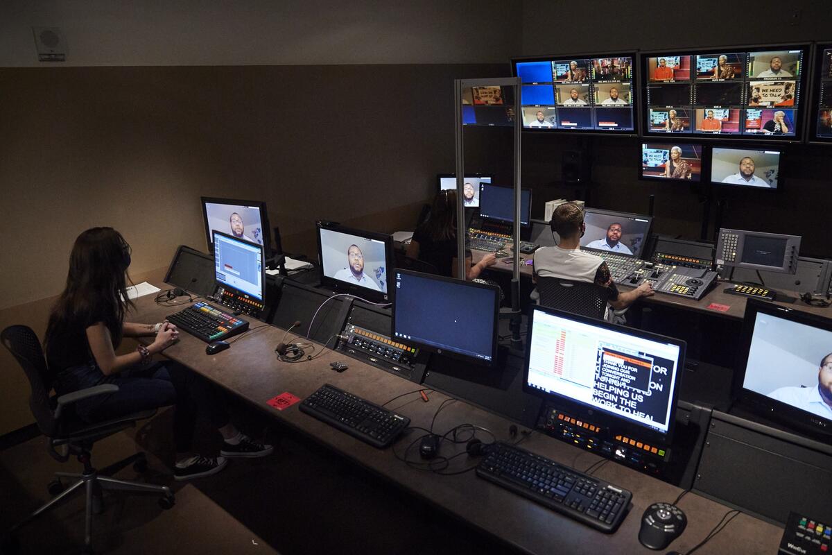 People in control center with multiple monitors
