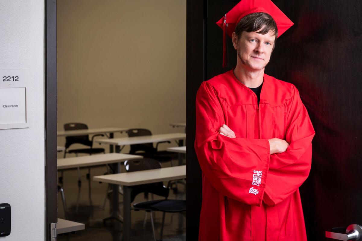 Person in graduation gown smiling