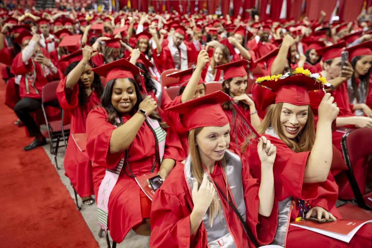 A group of graduates in red gowns and caps.