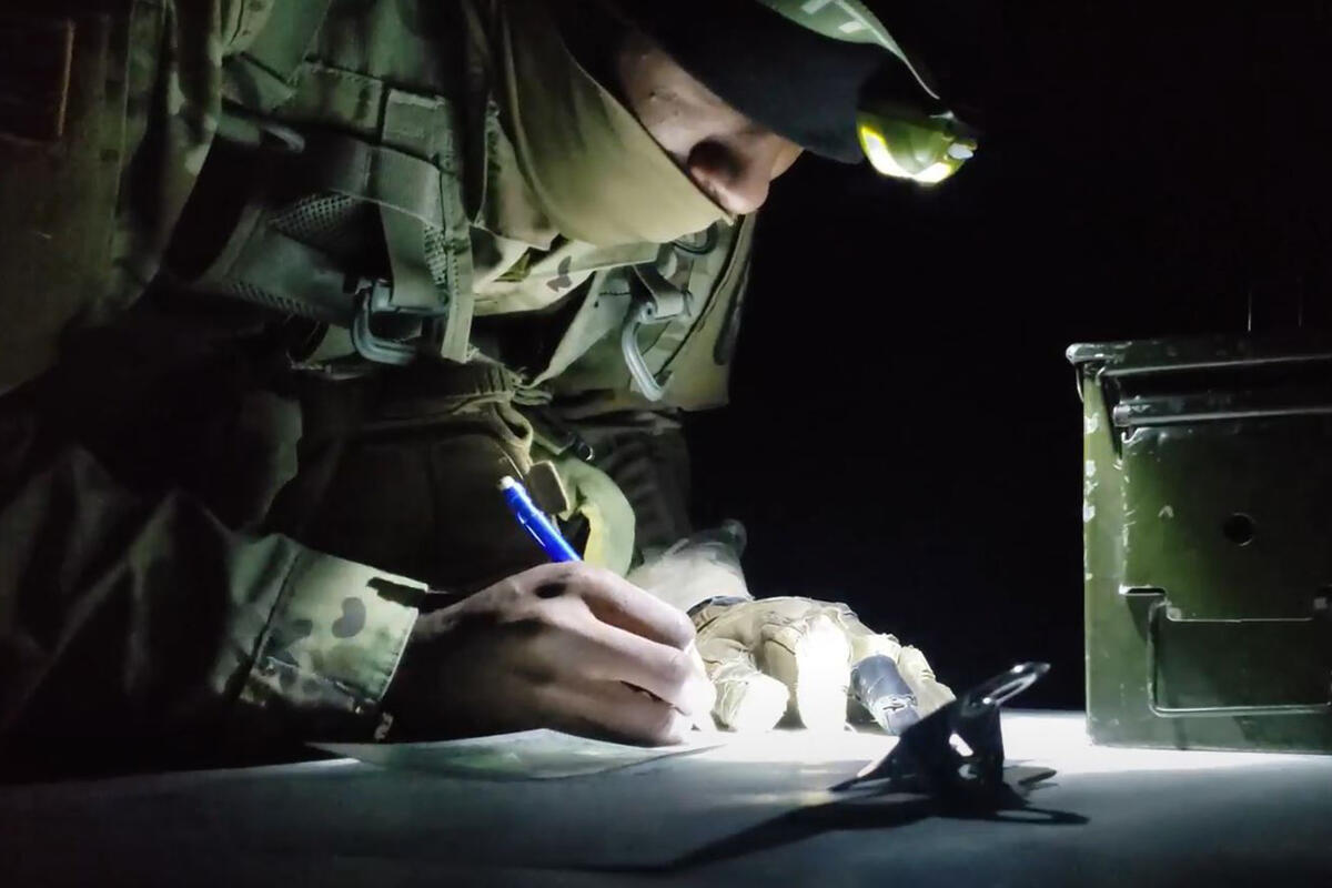 Soldier with headlamp looking at desk