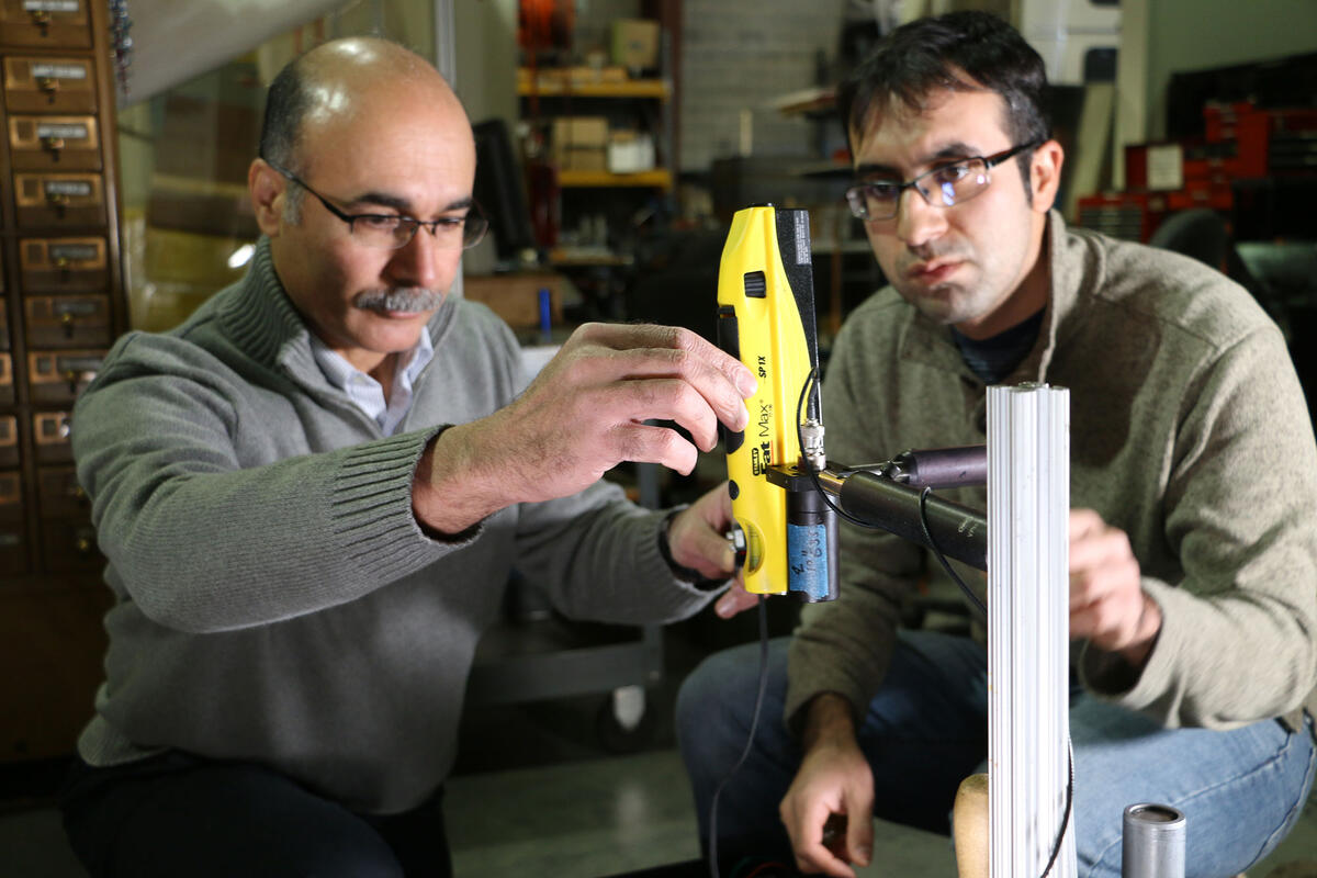 Two men look at a piece of railroad equipment.