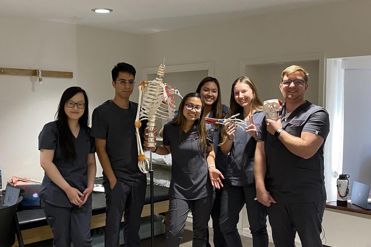 Group of students posing with a model skeleton