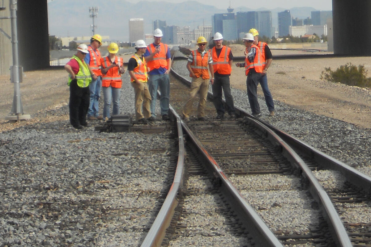 Railroad workers looking at train tracks