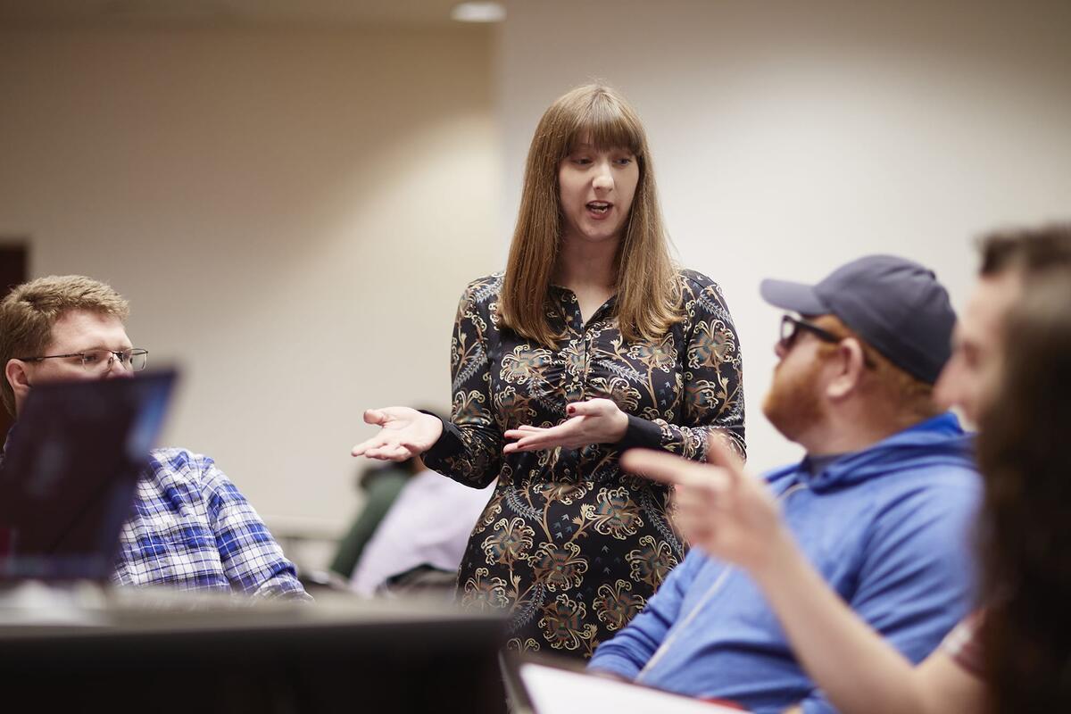 A student walking around class giving a presentation.