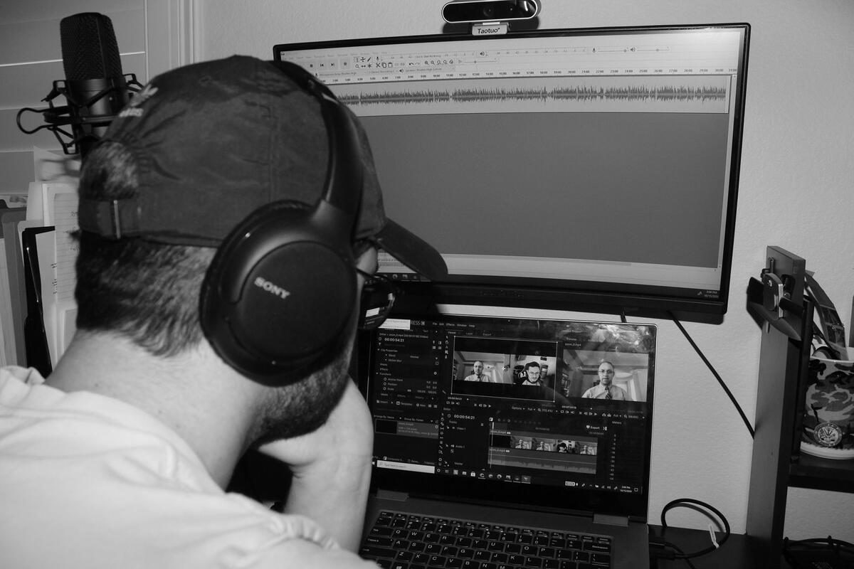 A man with headphones looking at a computer.