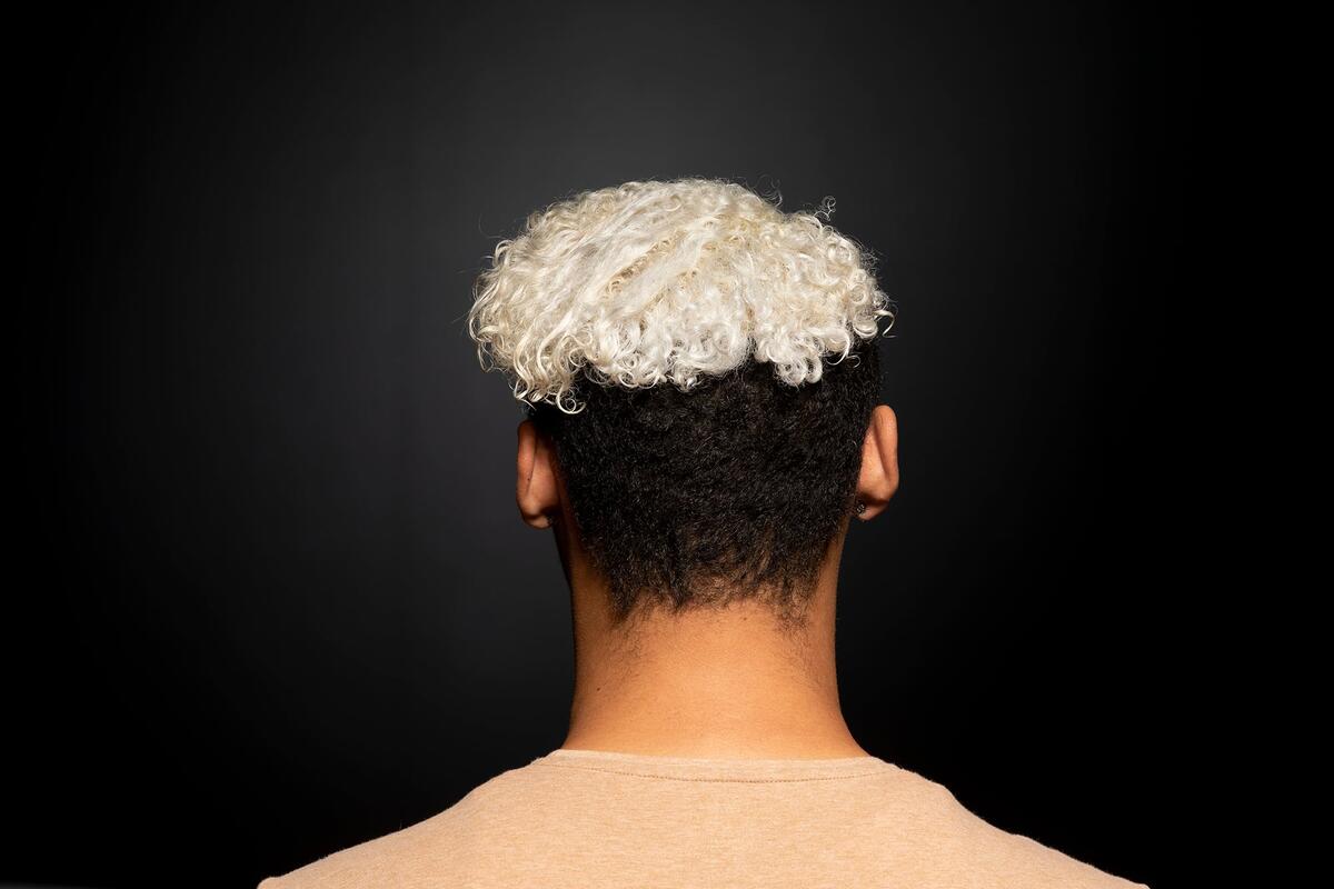 Back of person's head with dyed blond curly hair