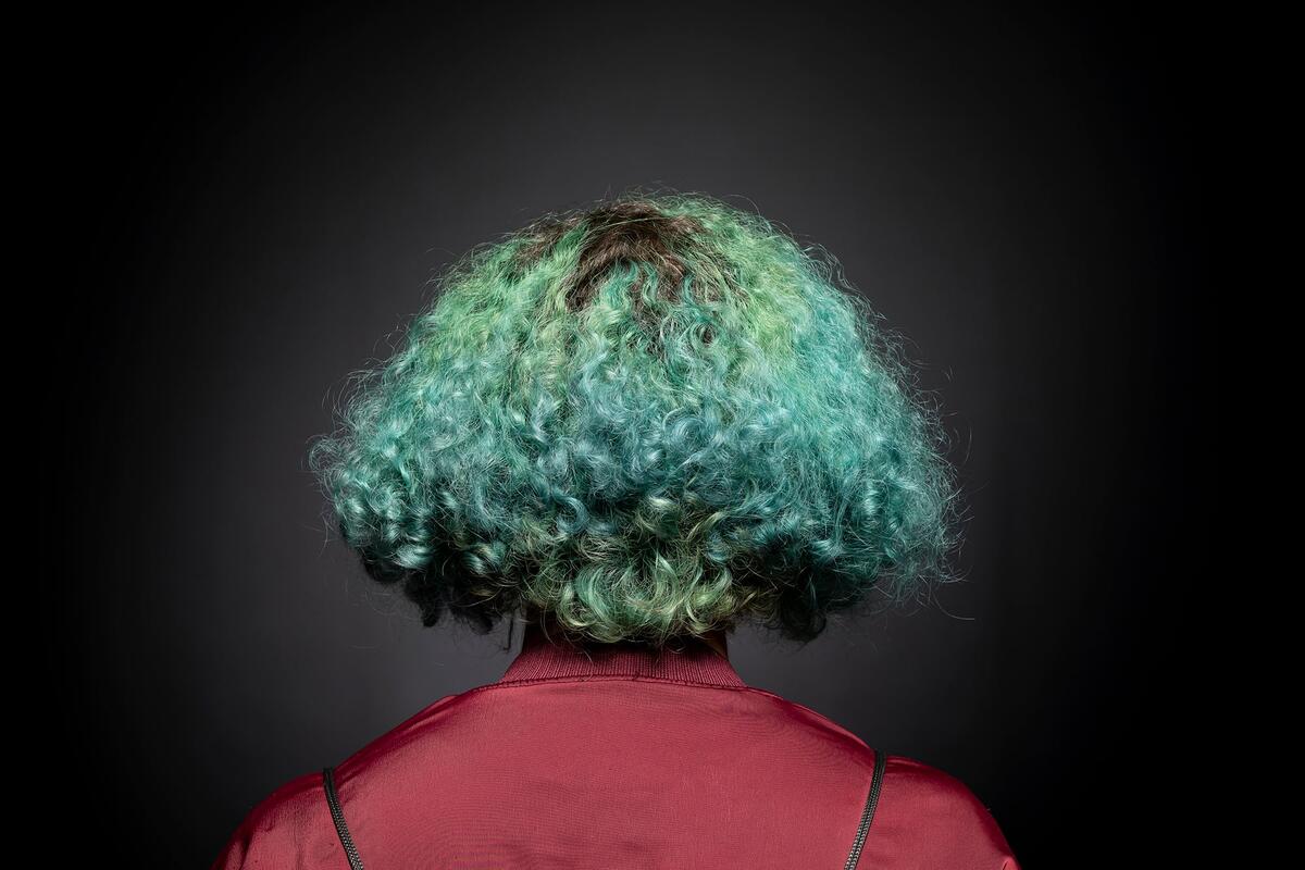 Back of person's head with curly green hair