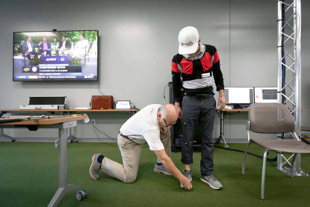A golf research lab with a man being measured for gear.