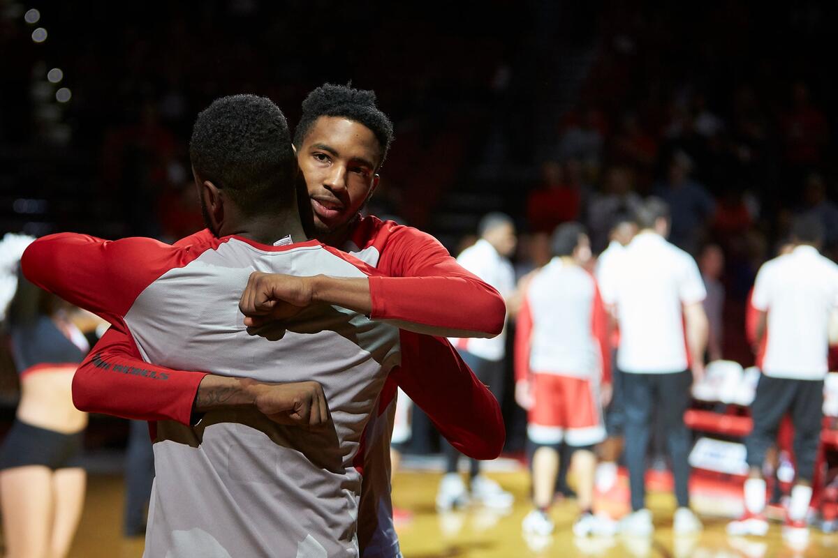 Two basketball players hug afer game