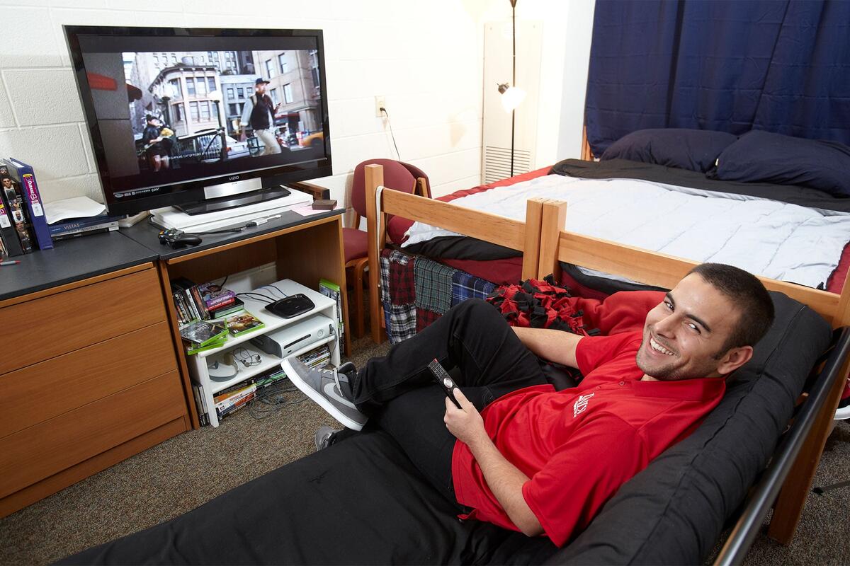 a student watching tv in his dorm room