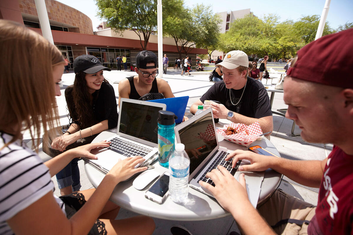 A group of students sitting down with their laptops