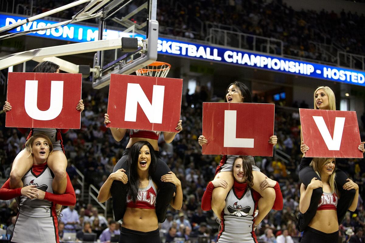 A group of cheerleaders holding up a UNLV sign