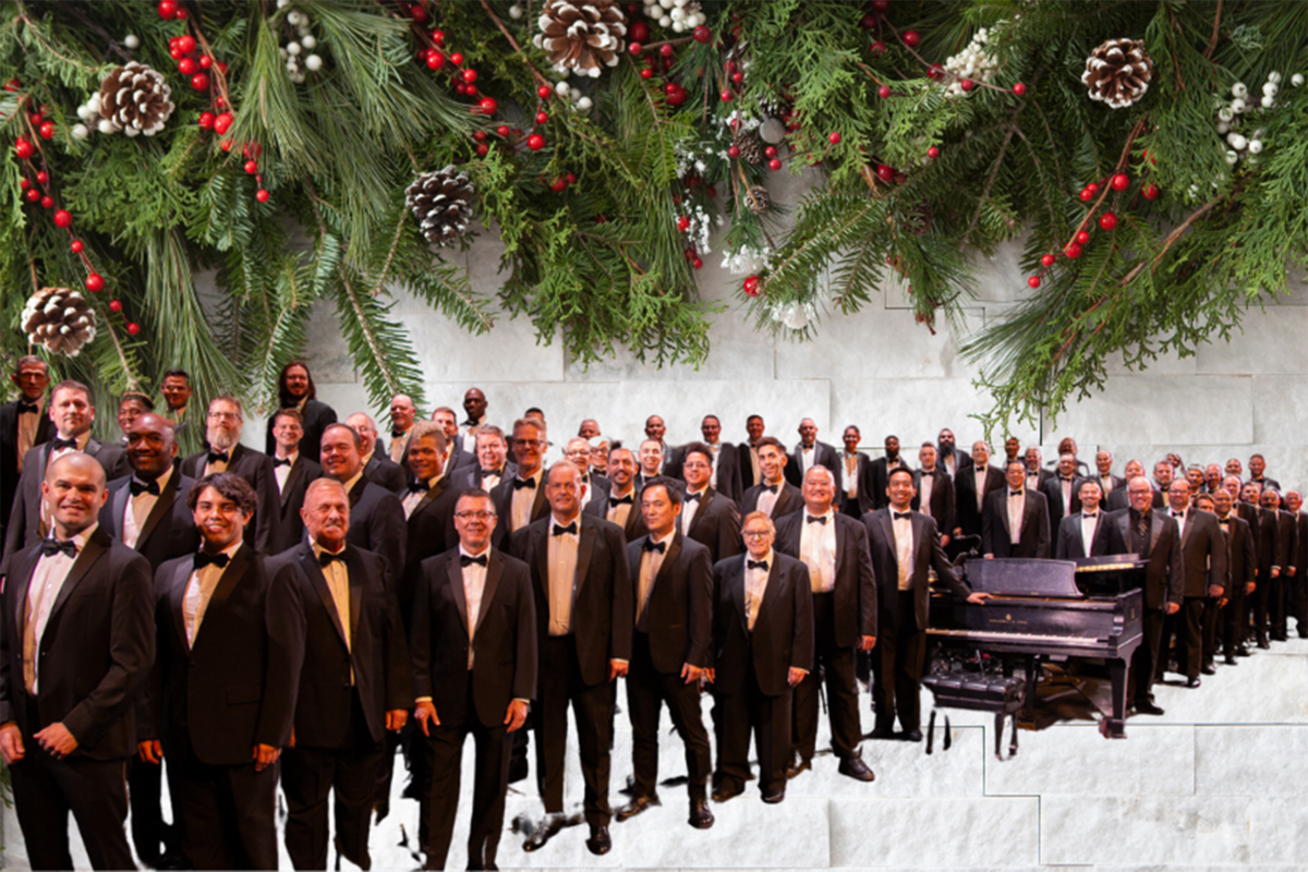 The Las Vegas Men's Chorus is shown underneath a holiday garland display.