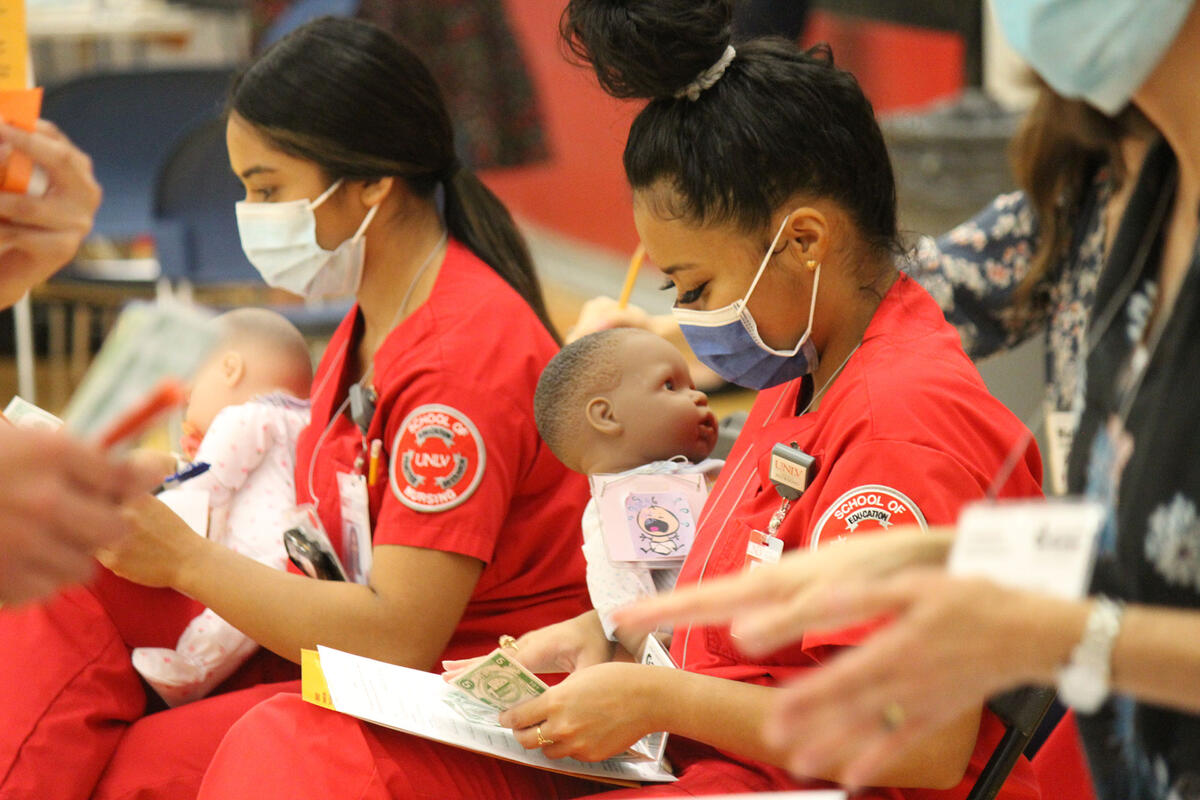 Two nursing students each holding a baby.