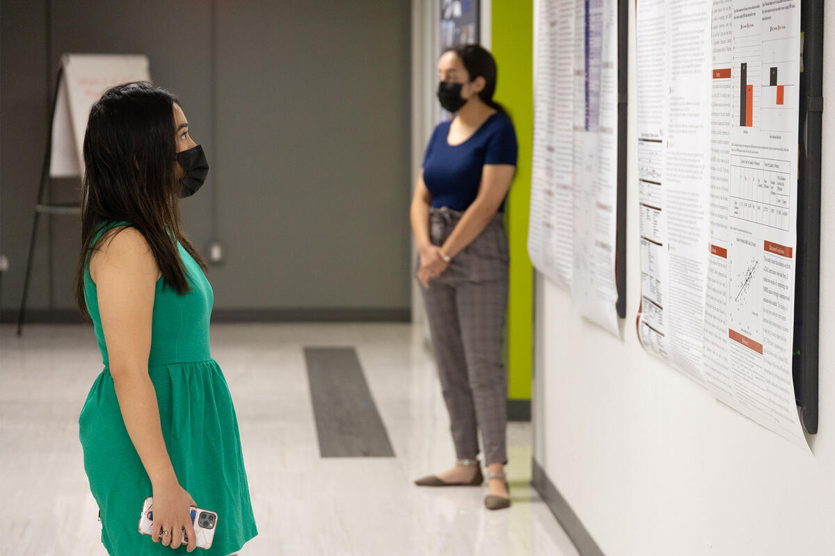 A student looking at a research poster at the Medical Research Society 2nd Annual Student Research Symposium in 2021.