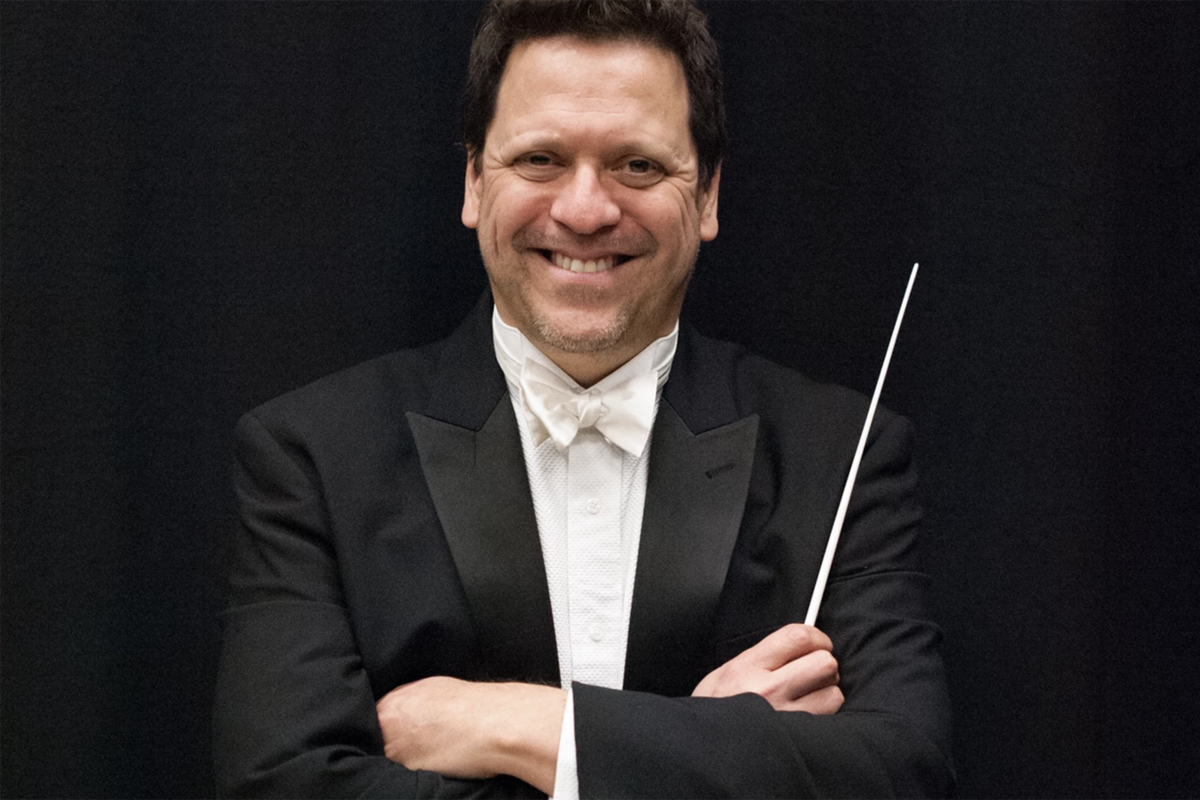 conductor posing in formal attire with baton