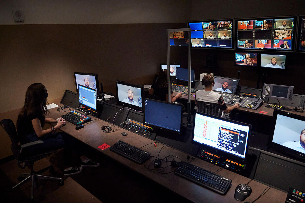 People inside of a recording studio with multiple screens.