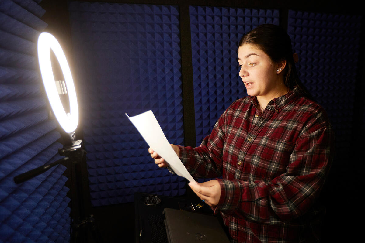 Student practicing a speech in a sound proof room
