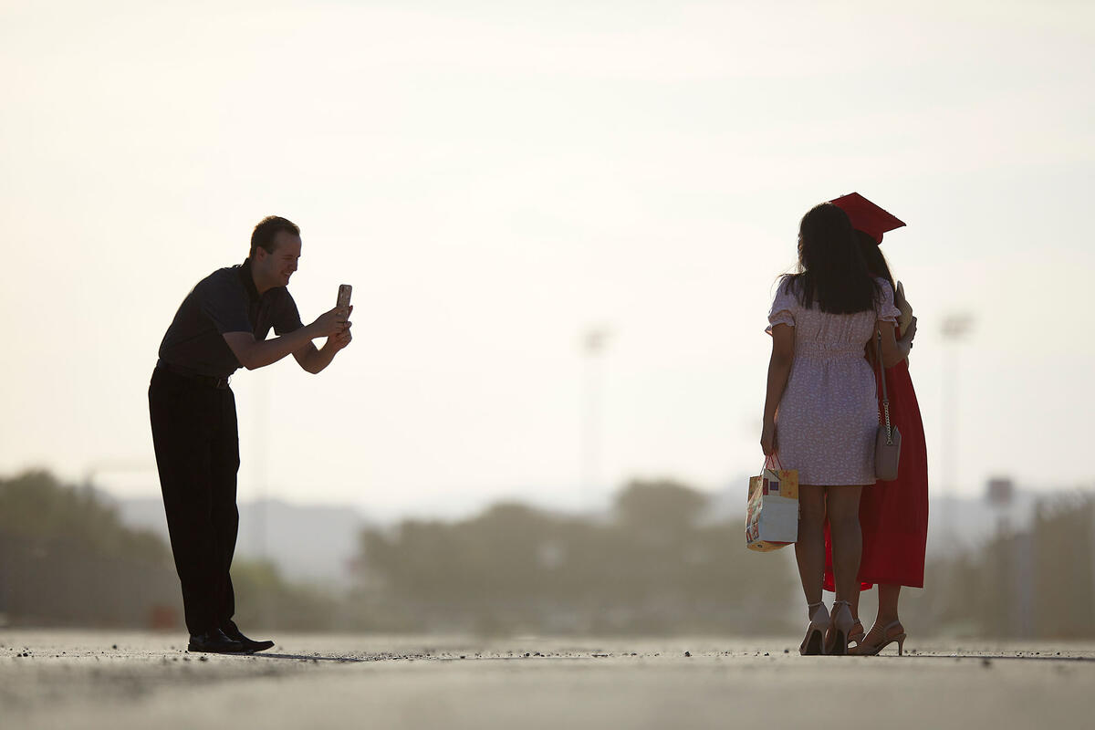 A man taking a picture of a woman and a child.