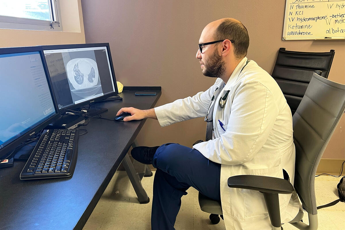 Dr. Iardino sits in front of a computer screne.