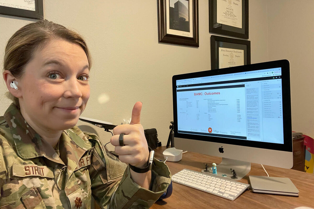 woman in military uniform signaling thumbs up