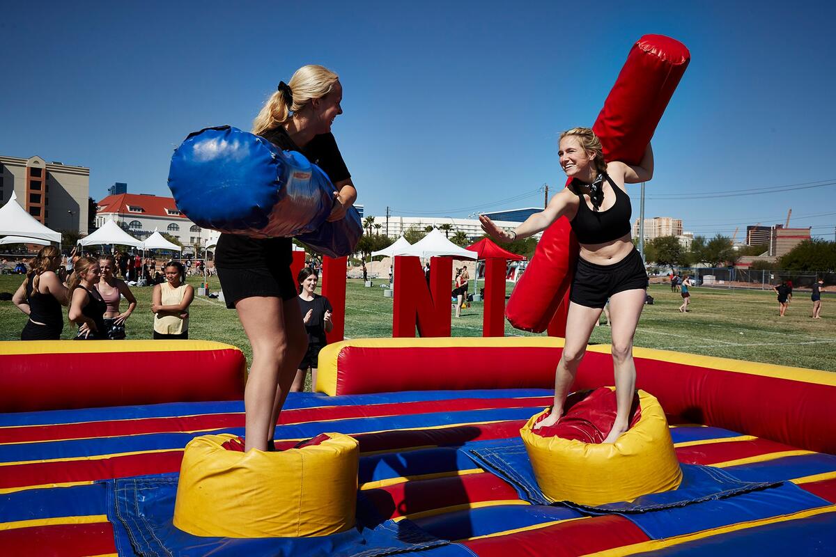 Two students compete in gladiator jousting