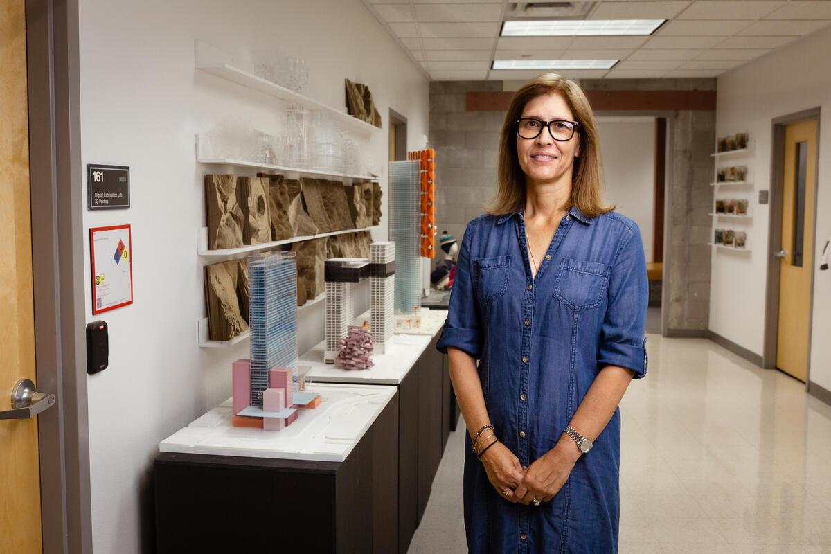 woman posing next to building models