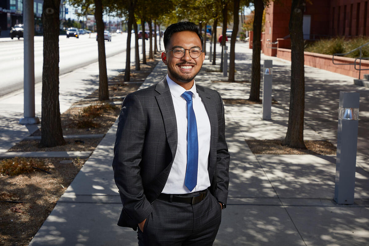 A man in a suit outside Greenspun College of Urban Affairs.