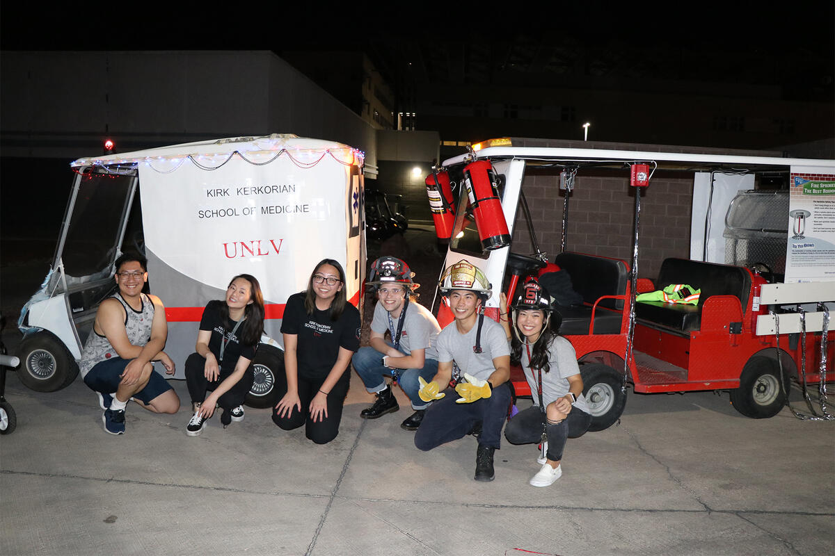 Medical students pose in front of the school of medicine's homecoming float alongside Fire and Life Safety's float